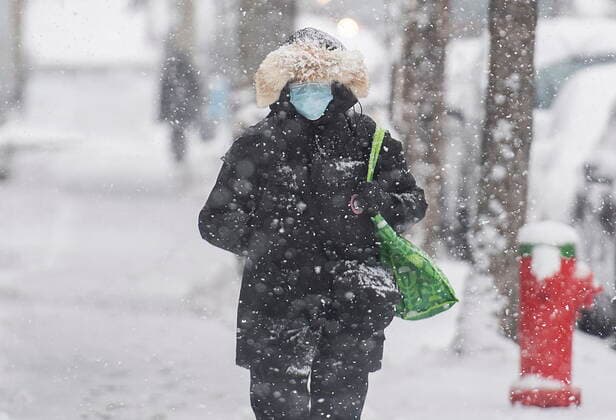 November 16, 2022, Montreal, PQ, Canada: A person wears a face mask as they walk along a street during snowfall in Montreal, Wednesday, November 16, 2022. The Quebec government has recommended wearing masks in public spaces. Montreal Canada  - ZUMAc35_ 20221116_zaf_c35_082 Copyright: xGrahamxHughesx