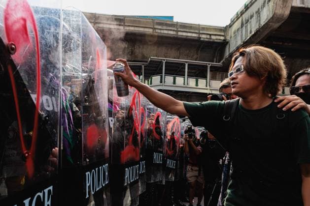 News Bilder des Tages November 17, 2022, Bangkok, Thailand: A protester sprays and paints communist logos on the riot police s shield during the demonstration. Pro-democracy protesters gathered at Asok intersection near Queen Sirikit National Convention Centre (QSNCC) where APEC is being held to protest in Bangkok. Bangkok Thailand - ZUMAs197 20221117_zaa_s197_030 Copyright: xVaruthxPongsapipattx