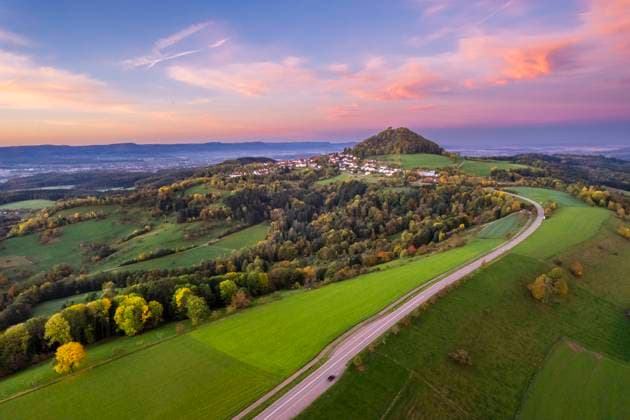 IMAGO Creative, Jahreszeit Herbst auf dem Land Germany, Baden-Wurttemberg, Drone view of country road stretching toward Hohenstaufen mountain, STSF03585