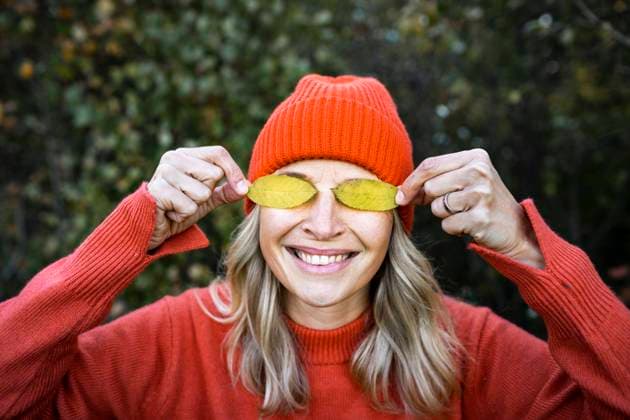Creative Highlights Symbolbilder Smiling mature woman covering eyes with autumn leaves model released, Symbolfoto, HMEF01469