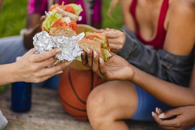 Women holding sandwich in park model released, Symbolfoto, JCCMF07924