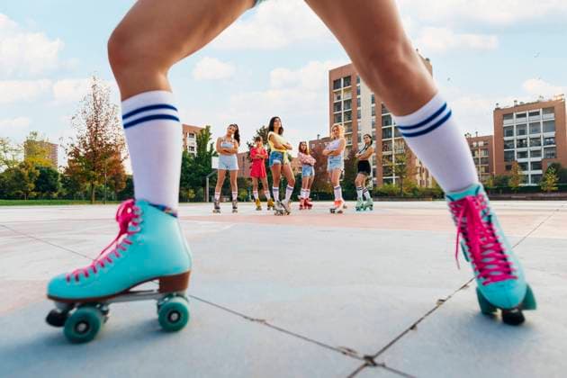 Creative Highlights Symbolbilder Friends wearing roller skates at sports court seen through woman s leg model released, Symbolfoto, MEUF08514
