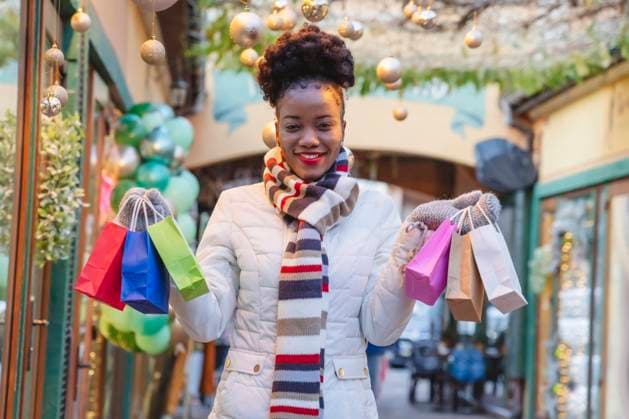 Smiling woman wearing warm clothing holding shopping bags on Christmas model released, Symbolfoto property released, OSF01131