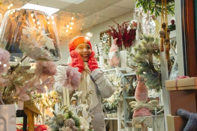 Surprised woman looking at Christmas decoration seen through glass model released, Symbolfoto property released, OSF01136
