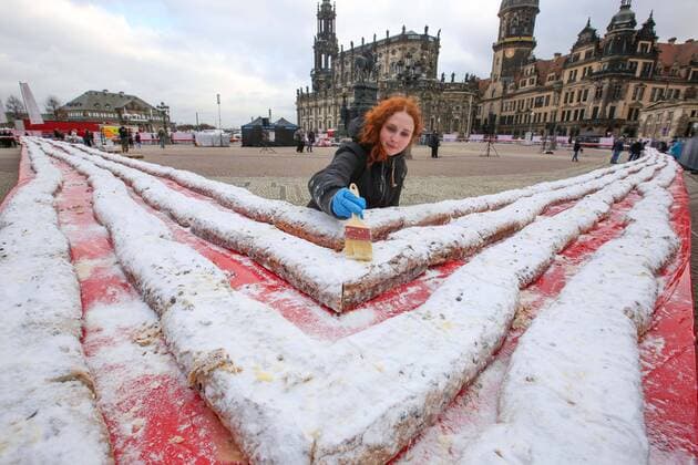 Bilder des Jahres, News 11 November Der groesste Stollen der Welt ist am 26.11.2022 auf dem Theaterplatz vor der Semperoper in Dresden praesentiert und verkauft worden (Foto vom 26.11.2022). Laut Abnahme des Rekordversuches durch das Rekord-Institut Deutschland brachte es das traditionelle Adventsgebaeck am Ende auf eine Laenge von mehr als 1.000 Metern. Hergestellt wurde der rund fuenf Tonnen schwere Striezel vor Hunderten von Zuschauern von der saechsischen Traditionsbaeckerei Emil Reimann, wie der Thueringer Verein Rekordteam als Veranstalter mitteilte. Die Herstellung von Riesenstollen und das Stollenfest haben eine lange Tradition in Dresden. Mit den Einnahmen soll ein sechsjaehriger Junge unterstuetzt werden, der an dem seltenen MED-13 L Syndrom leidet und Autist ist. Copyright: epd-bild MatthiasxSchumann epd-Stollenbacken5 - Kopieren