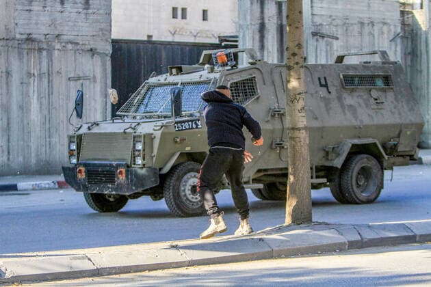 News Themen der Woche KW48 News Bilder des Tages December 2, 2022, Nablus, Palestine: A Palestinian youth throws stones at the Israeli army vehicle during an army raid on the house of the Palestinian gunman, Ahmed Al-Kharraz, to arrest him in the city of Nablus in the occupied West Bank. Nablus Palestine - ZUMAs197 20221202_zaa_s197_036 Copyright: xNasserxIshtayehx