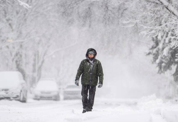 December 16, 2022, Ottawa, ON, CAN: A pedestrian walks in the ruts made by car tires as they make their way along a street in Ottawa s Glebe neighbourhood, as a snowfall warning is in effect for the region, on Friday, Dec. 16, 2022. Ottawa CAN  - ZUMAc35_ 20221216_zaf_c35_005 Copyright: xJustinxTangx