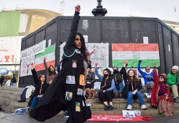 December 17, 2022, London, England, United Kingdom: A protester performs a dance with a noose around her neck and pictures of jailed protesters in Iran on her coat. A group of women staged a demonstration and performance in Piccadilly Circus in protest against the reported executions of anti-government protesters in Iran. The activists tied ropes around their necks and covered their hands in fake blood. London United Kingdom - ZUMAv130 20221217_zip_v130_009 Copyright: xVukxValcicx