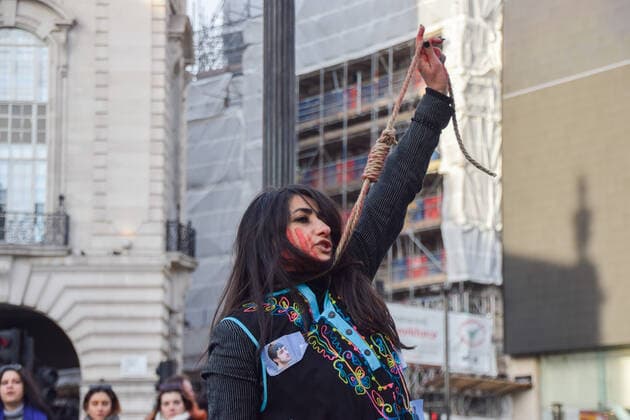 December 17, 2022, London, England, United Kingdom: A protester performs a dance with a noose around her neck. A group of women staged a demonstration and performance in Piccadilly Circus in protest against the reported executions of anti-government protesters in Iran. The activists tied ropes around their necks and covered their hands in fake blood. London United Kingdom - ZUMAv130 20221217_zip_v130_021 Copyright: xVukxValcicx