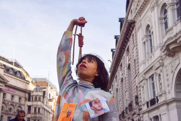 December 17, 2022, London, England, United Kingdom: A protester performs a dance with a noose around her neck. A group of women staged a demonstration and performance in Piccadilly Circus in protest against the reported executions of anti-government protesters in Iran. The activists tied ropes around their necks and covered their hands in fake blood. London United Kingdom - ZUMAv130 20221217_zip_v130_023 Copyright: xVukxValcicx