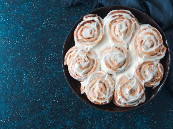 Vegan cinnamon rolls with topping, top view Idea and recipe pastries - perfect cinnamon rolls with topping, top view in skillet. Vegan swedish cinnamon buns Kanelbullar with pumpkin spice,topping vegan cream cheese.Flat lay. Copy space for text Copyright: xZoonar.com OlgaxSergeevax 15963708