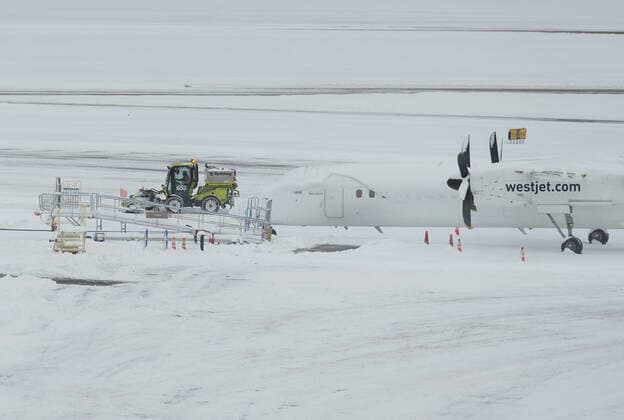 December 20, 2022, RICHMOND, BC, CANADA: A worker clears snow on the apron near a Westjet aircraft at Vancouver International Airport after a snowstorm crippled operations leading to cancellations and major delays, in Richmond, B.C., on Tuesday, December 20, 2022. RICHMOND CANADA  - ZUMAc35_ 20221220_zaf_c35_045 Copyright: xDarrylxDyckx