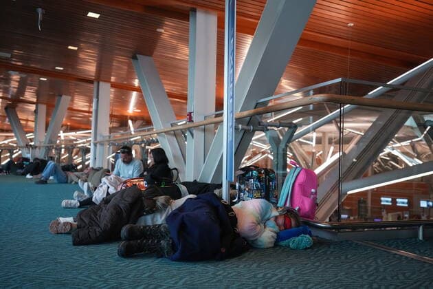 December 20, 2022, RICHMOND, BC, CANADA: A person sleeps on the floor at Vancouver International Airport after a snowstorm crippled operations leading to cancellations and major delays, in Richmond, B.C., on Tuesday, December 20, 2022. RICHMOND CANADA  - ZUMAc35_ 20221220_zaf_c35_049 Copyright: xDarrylxDyckx