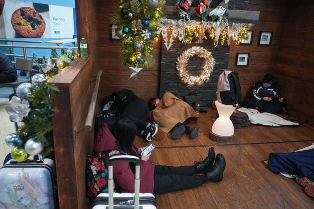 December 20, 2022, RICHMOND, BC, CANADA: People sleep as others sit on the floor in a holiday display at Vancouver International Airport after a snowstorm crippled operations leading to cancellations and major delays, in Richmond, B.C., on Tuesday, December 20, 2022. RICHMOND CANADA  - ZUMAc35_ 20221220_zaf_c35_055 Copyright: xDarrylxDyckx