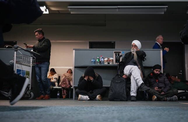December 20, 2022, RICHMOND, BC, CANADA: People sit on the floor at Vancouver International Airport after a snowstorm crippled operations leading to cancellations and major delays, in Richmond, B.C., on Tuesday, December 20, 2022. RICHMOND CANADA  - ZUMAc35_ 20221220_zaf_c35_058 Copyright: xDarrylxDyckx