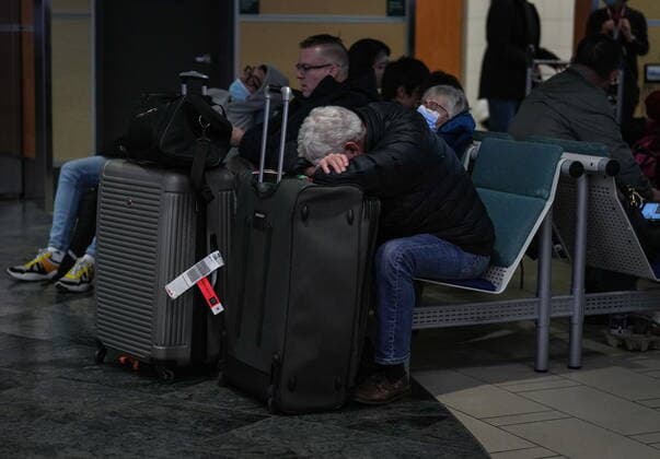 December 20, 2022, RICHMOND, BC, CANADA: A man rests on his luggage at Vancouver International Airport after a snowstorm crippled operations leading to cancellations and major delays, in Richmond, B.C., on Tuesday, December 20, 2022. RICHMOND CANADA  - ZUMAc35_ 20221220_zaf_c35_067 Copyright: xDarrylxDyckx