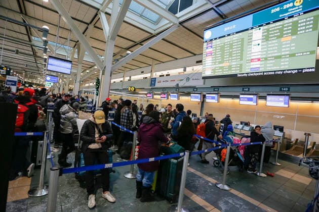 (221220) -- RICHMOND (CANADA), Dec. 20, 2022 -- Passengers wait in a check-in line at Vancouver International Airport in Richmond, British Columbia, Canada, on Dec. 20, 2022. Thousands of travelers were stuck at the Vancouver International Airport on Tuesday as many flights were cancelled or delayed due to the snowstorm. (Photo by Xinhua) CANADA-VANCOUVER INTERNATIONAL AIRPORT-SNOWSTORM-STRANDED PASSENGERS LiangxSen 
