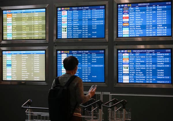 (221220) -- RICHMOND (CANADA), Dec. 20, 2022 -- A passenger reads flight information at Vancouver International Airport in Richmond, British Columbia, Canada, on Dec. 20, 2022. Thousands of travelers were stuck at the Vancouver International Airport on Tuesday as many flights were cancelled or delayed due to the snowstorm. (Photo by Xinhua) CANADA-VANCOUVER INTERNATIONAL AIRPORT-SNOWSTORM-STRANDED PASSENGERS LiangxSen 