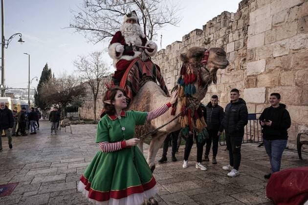 News Themen der Woche KW51 News Bilder des Tages December 22, 2022, Jerusalem, Israel: Santa Claus, or Baba Noel as he is called in Arabic, is escorted by an elf as he rides a camel substitute for reindeer at Jerusalem s Old City New Gate. The Jerusalem Municipality and the Jewish National Fund distributed specially grown Arizona Cypress Christmas trees to the Christian population at the Jaffa Gate. Jerusalem Israel - ZUMAa126 20221222_zap_a126_006 Copyright: xNirxAlonx