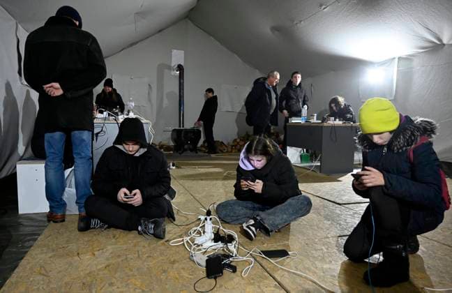 News Bilder des Tages December 22, 2022, Kyiv, Ukraine: People charge their mobile phones at the mobile police station during a blackout in Kyiv. The Russian army carried out massive rocket and kamikaze drone attacks on Ukrainian energy infrastructure. After severe damage to the power grid in many cities of Ukraine, the National Power Company Ukrenergo introduced emergency and hourly blackouts of electricity. Kyiv Ukraine - ZUMAs197 20221222_zab_s197_033 Copyright: xSergeixChuzavkovx