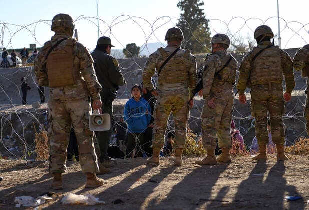 December 21, 2022, El Paso, Texas, USA: Migrants seeking asylum received instructions from members of the Texas National Guard and Texas Department of Public Safety Wednesday December 21, 2022 along the U.S. Mexico border in El Paso, Texas. Both the Texas National Guard and DPS are set to provide safety and encourage people to head to the ports of entry and seek asylum there rather than camp along the river. El Paso USA  - ZUMA 20221221_new_h170_128 Copyright: xJ.R.xHernandezx