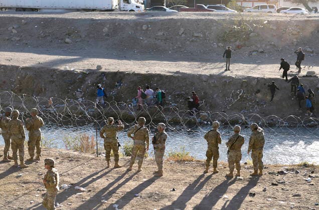 December 21, 2022, El Paso, Texas, USA: Migrants seeking asylum are deterrent ofter received instructions from members of the Texas National Guard and Texas Department of Public Safety Wednesday December 21, 2022 along the U.S. Mexico border in El Paso, Texas. Both the Texas National Guard and DPS are set to provide safety and encourage people to head to the ports of entry and seek asylum there rather than camp along the river. El Paso USA  - ZUMA 20221221_new_h170_130 Copyright: xJ.R.xHernandezx