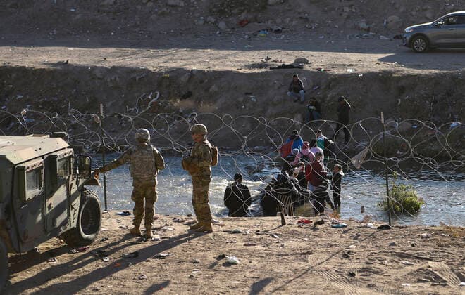 December 21, 2022, El Paso, Texas, USA: Migrants seeking asylum are deterrent ofter received instructions from members of the Texas National Guard and Texas Department of Public Safety Wednesday December 21, 2022 along the U.S. Mexico border in El Paso, Texas. Both the Texas National Guard and DPS are set to provide safety and encourage people to head to the ports of entry and seek asylum there rather than camp along the river. El Paso USA  - ZUMA 20221221_new_h170_131 Copyright: xJ.R.xHernandezx