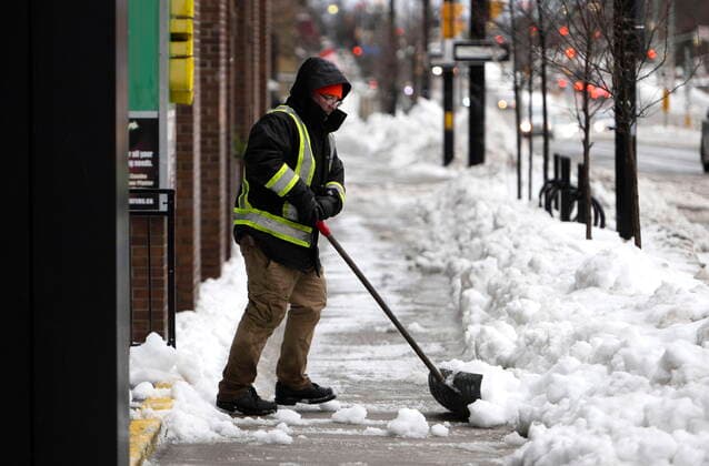 December 23, 2022, Ottawa, ON, CAN: A worker shovels snow in Ottawa, as a winter storm warning is in effect, on Friday, Dec. 23, 2022. Ottawa CAN  - ZUMAc35_ 20221223_zaf_c35_012 Copyright: xJustinxTangx