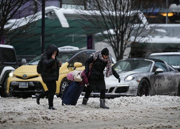 December 23, 2022, VANCOUVER, BC, CANADA: A woman struggles to pull luggage across a snow-covered street in downtown Vancouver, on Friday, December 23, 2022. VANCOUVER CANADA  - ZUMAc35_ 20221223_zaf_c35_066 Copyright: xDarrylxDyckx