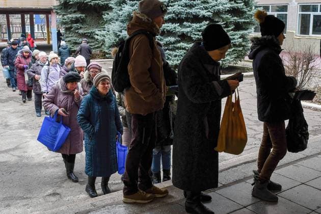 December 24, 2022, Kramatorsk, Donetsk, Ukraine: People stand in a line to receive bread at a humanitarian aid distribution point in Kramatorsk. Russian forces keep pounding critical power infrastructure in Ukrainian cities, killing more civilians and leaving tens of thousands of more people without electricity, as its troops step up the pace of their relentless attacks along the entire front line in the east. Kramatorsk Ukraine - ZUMAs197 20221224_zab_s197_088 Copyright: xAndriyxAndriyenkox