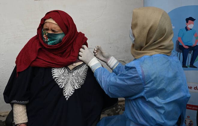 SRINAGAR, INDIA - DECEMBER 27: A woman receives a shot of booster dose of COVID19 vaccine on December 27, 2022 in Srinagar, India. Reports of a massive surge in Covid-19 infections in China and apprehensions over the possibility of a spill-over effect in India has led to a sharp uptick in the vaccination intake in the country. In the past week on Friday (December 23) and Saturday, more than one lakh vaccinations were administered in India against an average of between 40,000 and 50,000 doses through most of this month.(Photo By Waseem Andrabi Hindustan Times) Amid China Scare, Covid Booster Vaccination Picks Up In India