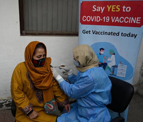 SRINAGAR, INDIA - DECEMBER 27: A woman receives a shot of booster dose of COVID19 vaccine on December 27, 2022 in Srinagar, India. Reports of a massive surge in Covid-19 infections in China and apprehensions over the possibility of a spill-over effect in India has led to a sharp uptick in the vaccination intake in the country. In the past week on Friday (December 23) and Saturday, more than one lakh vaccinations were administered in India against an average of between 40,000 and 50,000 doses through most of this month.(Photo By Waseem Andrabi Hindustan Times) Amid China Scare, Covid Booster Vaccination Picks Up In India