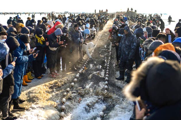 News Themen der Woche KW52 News Bilder des Tages (221228) -- SONGYUAN, Dec. 28, 2022 -- Tourists watch winter fishing on the Chagan Lake in Songyuan City, northeast China s Jilin Province, Dec. 28, 2022. A winter fishing-themed festival opened on Wednesday at Chagan Lake, marking the beginning of the annual golden season for winter fishing here. Chagan Lake, located in Songyuan City, is one of China s largest freshwater lakes with abundant fishery resources. For centuries, the locals living by Chagan Lake have kept alive the tradition of ice fishing by hand-drilling holes through the thick ice and casting nets into the icy waters to catch fish. After years of promotion, winter fishing at Chagan Lake has become a famous tourism attraction in the city. ) CHINA-JILIN-SONGYUAN-WINTER F 