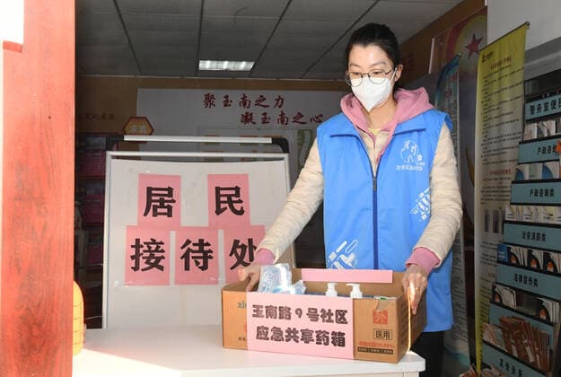 (221227) -- BEIJING, Dec. 27, 2022 -- A staff member puts a shared medical kit at the entrance of a residential community in Yangfangdian Subdistrict of Haidian District in Beijing, capital of China, Dec. 27, 2022. In Yangfangdian Subdistrict, care packages including medicines and COVID-19 prevention materials have been offered for senior residents living alone and those with disabilities. Shared medical kits have also been provided for residents in case of emergency. ) CHINA-BEIJING-COVID-19 PREVENTION-CARE PACKAGES (CN) RenxChao 
