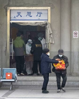 Wuhan amid COVID surge An official in protective gear attends to guests at a funeral hall in Wuhan on Dec. 29, 2022, amid a surge in COVID-19 cases. The Chinese government eased its strict antivirus measures earlier in the month.  A14AA0001380145P