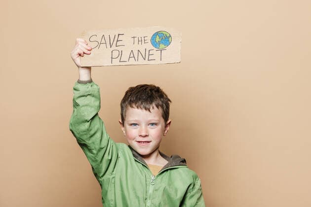 Boy demonstrating carton placard with Save the Planet inscription and hand drawn Earth against beige background, Model released, Property released HodeiUnzueta_ID10634_321997_041 Copyright: xHodeixUnzuetax MR