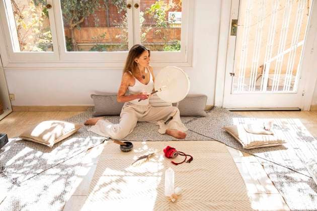 Woman practicing sound healing with frame drum at home model released, Symbolfoto property released, MEGF00346