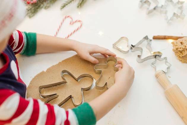 Hands of boy using cookie cutter on gingerbread dough in kitchen model released, Symbolfoto property released, ONAF00301