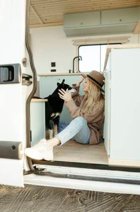 Young woman playing with dog inside motor home model released, Symbolfoto property released, RCPF01507