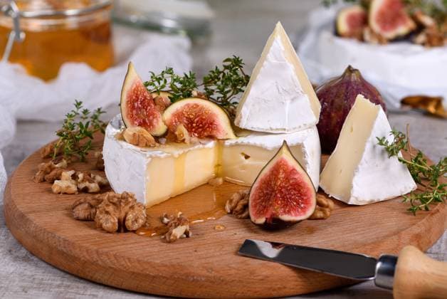 Brie cheese with honey and figs Brie cheese served on a wooden board with figs, walnuts and honey Copyright: xZoonar.com MarynaxVoronovax 18129122