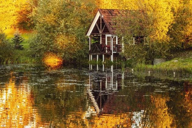IMAGO Creative, Architektur, Zukunftsmodell Tiny house Red holiday cabin with reflection in the pond during sunset, Red holiday cabin with reflection in the pond during sunset. Wooden cottage, sauna on shore. Tiny house near the water. Building surrounded by autumn trees., Red holiday cabin with reflection in the pond during sunset. Wooden cottage, sauna on shore. Tiny house near the water. Building surrounded by autumn trees., 11.10.2022, Copyright: xgrajax Panthermedia32432338.jpg