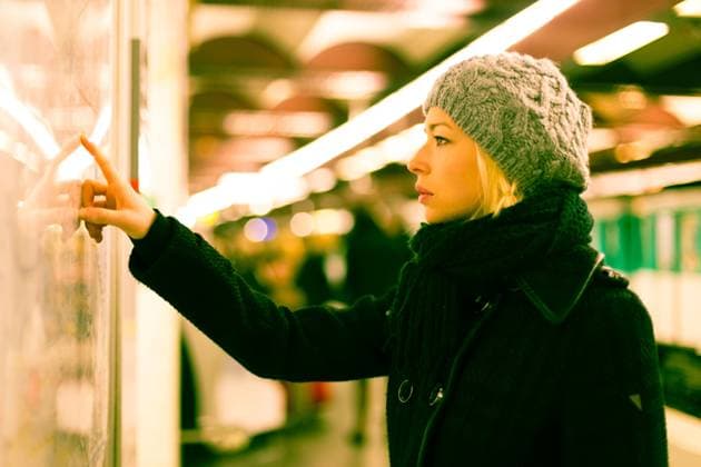 Lady looking on public transport map panel. Casually dressed woman wearing winter coat, orientating herself with public transport map panel, pointing on her final destination. Urban transport. Copyright: xZoonar.com MatejxKastelicx 11789708 ,model released, Symbolfoto ,property released