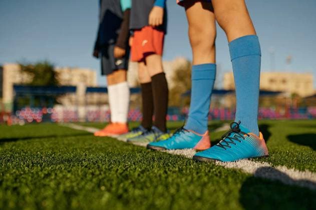  Closeup leg of teenage football player on white line across green lawn, Closeup leg of teenage football player on white line across green soccer lawn with artificial grass, Closeup leg of teenage football player on white line across green soccer lawn with artificial grass, 02.01.2023, Copyright: xNomadSoulx Panthermedia33405683.jpg