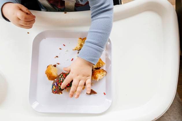 Creative Highlights Symbolbilder Young Boy Eating Chocolate Sprinkle Donut in Highchair Saint Paul, Minnesota, United States R_MZGL230113-1107970-01 ,model released, Symbolfoto