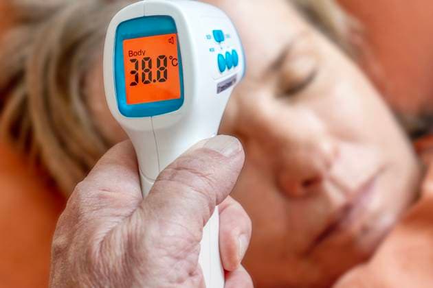 Kontaktlos Fiebermessen, ältere Frau liegt mit Grippe im Bett, München, Januar 2023 Deutschland, München, 22.01.2023, kontaktlos Fiebermessen, ältere Frau liegt mit Grippe im Bett, Infrarot Thermoter wird mit Abstand an die Stirn gehalten, Stirntemperatur messen, Digitalanzeige zeigt 38,8 Grad Fieber, Ü60, Senioren, Symbolfoto Grippewelle, Influenza, Erkältungswelle, Krankschreibung, Gesundheit, *** Contactless fever measuring, older woman lies with flu in the bed, Munich, January 2023 Germany, Munich, 22 01 2023, contactless fever measuring, older woman lies with flu in the bed, infrared Thermoter is held with distance to the forehead, forehead temperature measure, digital display shows 38.8 degrees fever, Ü60, seniors, symbol photo