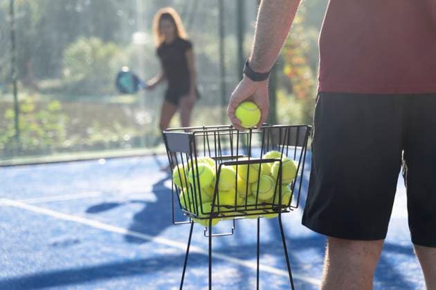 Man holding tennis ball with woman standing in background model released, Symbolfoto property released, FMOF01608