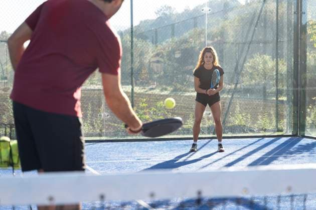 Young man playing paddle tennis with woman on sunny day model released, Symbolfoto property released, FMOF01610