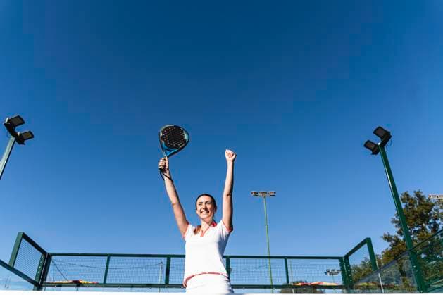 Happy woman cheering at sports court on sunny day model released, Symbolfoto property released, FMOF01623