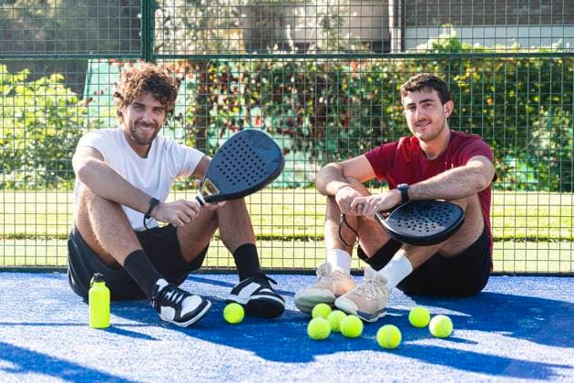 Friends sitting with tennis rackets and balls at sports court model released, Symbolfoto property released, FMOF01624