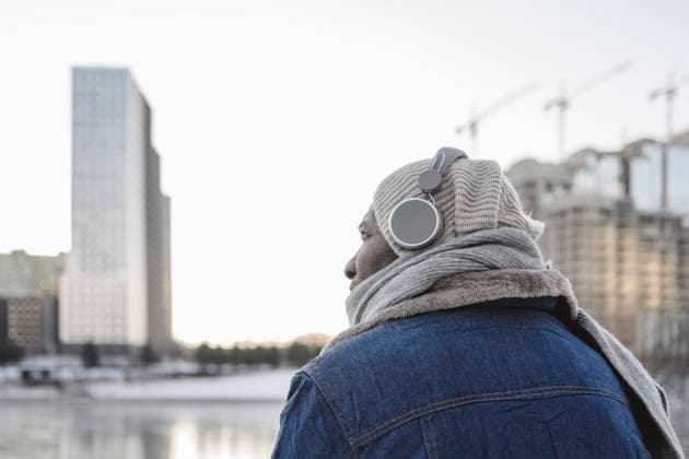 IMAGO Creative, Jahreszeit Winter in der Stadt Mature man listening to music through headphones in winter model released, Symbolfoto, EYAF02507